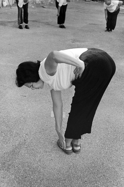 Black and white image of a woman bending over and touching her toes.